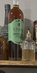 Kelby’s King’s Ryeconic bottle beside bitters on his home bar shelf